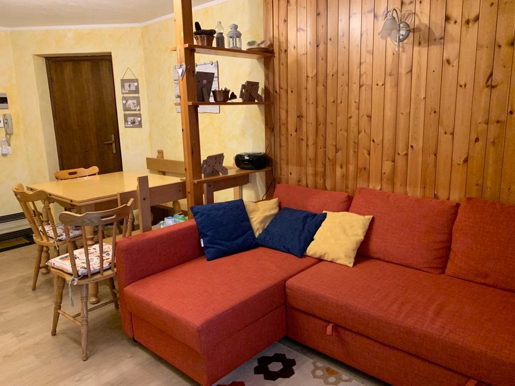 Soggiorno con divano ad angolo e sala da pranzo